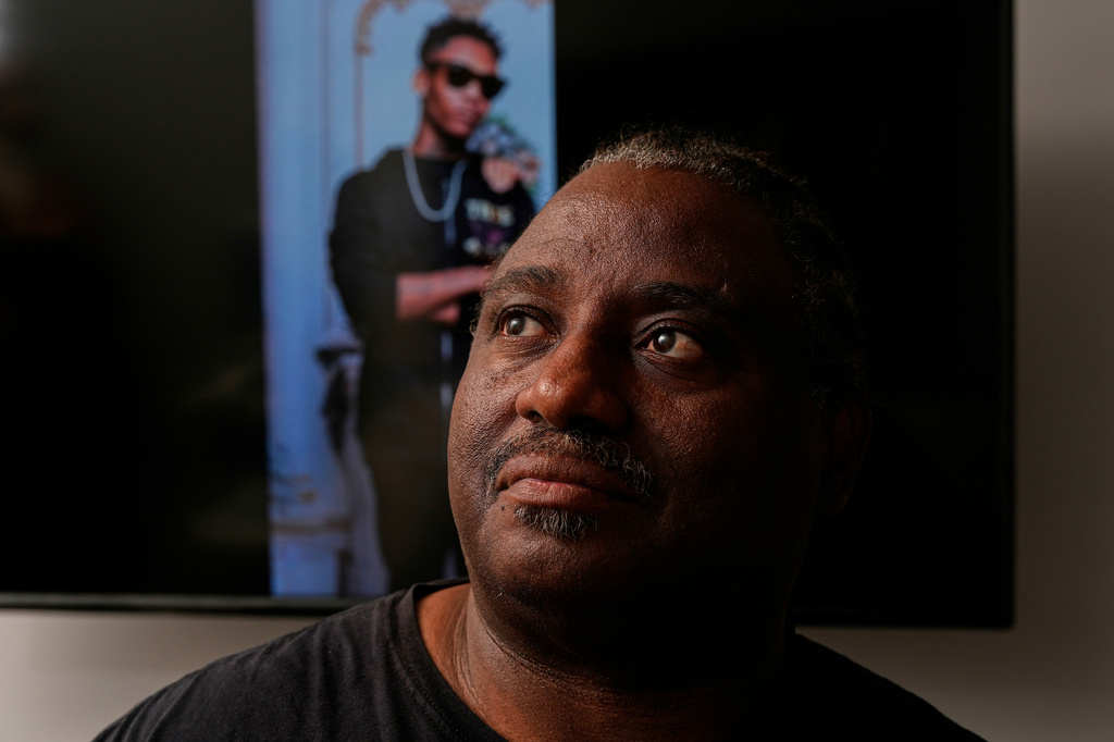 FILE - Evaniel Johnson poses with a picture of his grandson, Tyrin Johnson, Monday, July 6, 2026, in Nashville, Tenn., after his grandson was fatally shot by two Tennessee National Guard members in Memphis on Sunday, morning. (AP Photo/George Walker IV,File)
