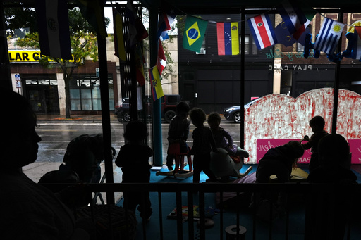 A nanny keeps watch as children play in the window at Luna y Cielo Play Cafe, where they practice and learn Spanish through play, in Chicago's Logan Square neighborhood, Wednesday, Oct. 15, 2025. (AP Photo/Rebecca Blackwell) A nanny keeps watch as children play in the window at Luna y Cielo Play Cafe, where they practice and learn Spanish through play, in Chicago's Logan Square neighborhood, Wednesday, Oct. 15, 2025. (AP Photo/Rebecca Blackwell)