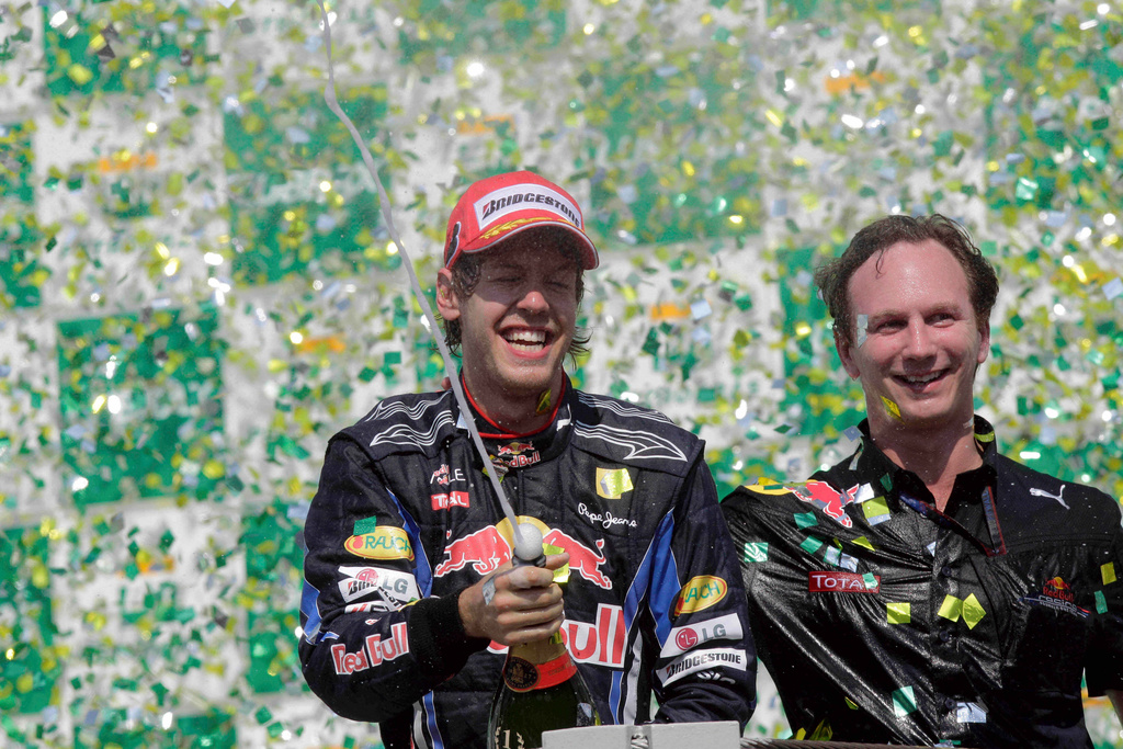 FILE - First place Red Bull driver Sebastian Vettel, of Germany, celebrates as Red Bull team principal Christian Horner looks on at the podium after winning Brazil's Formula One Grand Prix at the Interlagos race track in Sao Paulo, Brazil, Nov. 7, 2010. (AP Photo/Luca Bruno, File)