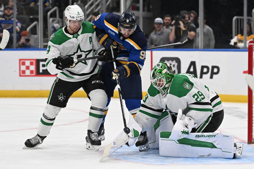 Dallas Stars Miro Heiskanen (4), left, and teammate goaltender Jake Oettinger (29) defend the net against St. Louis Blues' Robby Fabbri (9) during the second period of an NHL hockey game on Tuesday, Jan. 27, 2026, in St. Louis. (AP Photo/Joe Puetz)