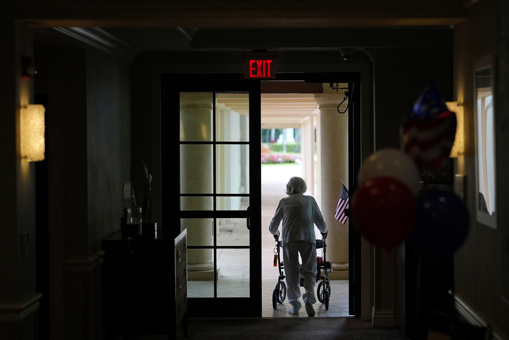 FILE - A woman uses a walker as she exits an assisted living building at the Toby and Leon Cooperman Sinai Residences, July 4, 2025, in Boca Raton, Fla. (AP Photo/Rebecca Blackwell, File)