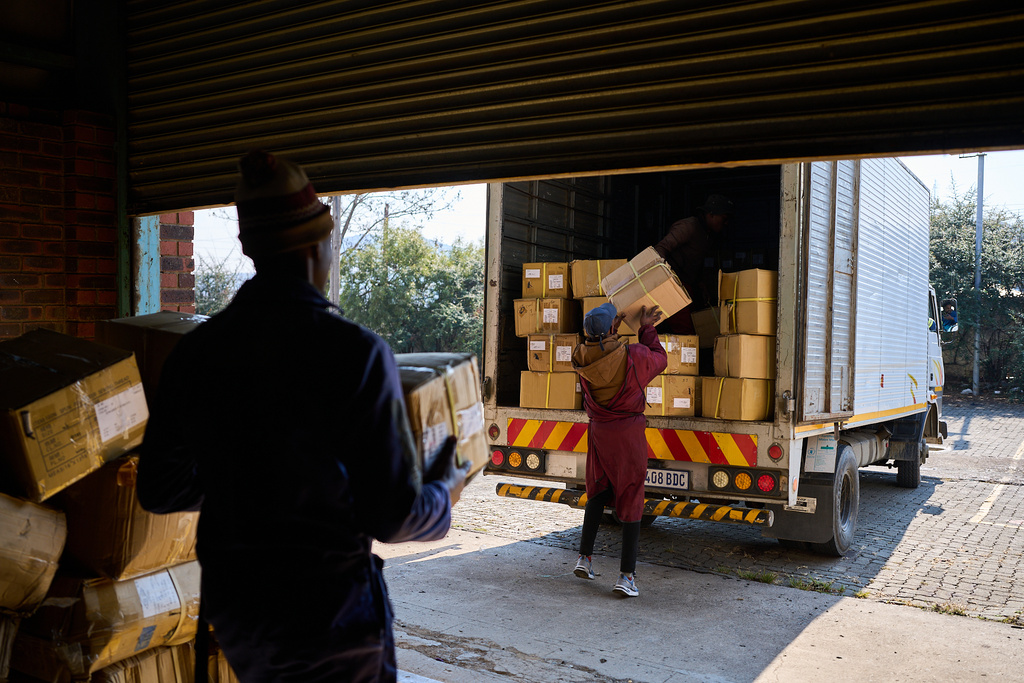 FILE - Workers load a truck with the last boxes filled with clothes from the empty Tzicc clothing factory following the threat of U.S.-imposed tariffs in Maseru, Lesotho, July 22, 2025. (AP Photo/Bram Janssen, File)