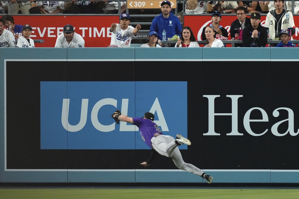 Colorado Rockies center fielder Brenton Doyle makes a case ch on a ball hit by Los Angeles Dodgers' Freddie Freeman during the first inning of a baseball game Wednesday, Sept. 10, 2025, in Los Angeles. (AP Photo/Mark J. Terrill)