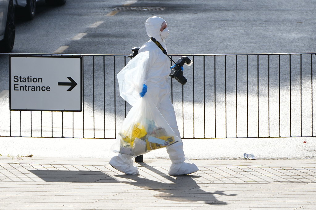 A forensic investigator carries evidence after a mass stabbing on a London-bound train at a train station in Huntingdon, England, Sunday, Nov. 2, 2025.(AP Photo/Kirsty Wigglesworth)