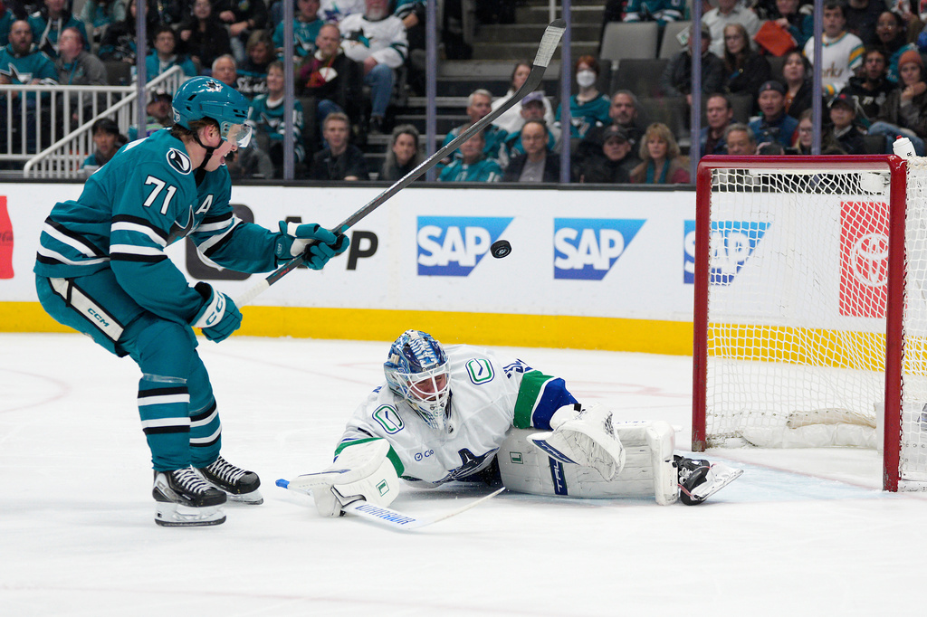 Vancouver Canucks goaltender Kevin Lankinen, right, blocks a shot by San Jose Sharks center Macklin Celebrini (71) during the first period of an NHL hockey game in San Jose, Calif., Saturday, April 11, 2026. (AP Photo/Tony Avelar)