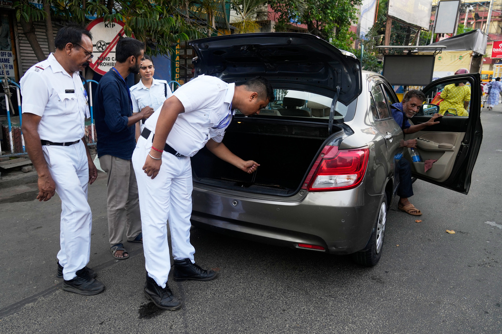 Police personnels check a car as part of security measures ahead of the West Bengal state Legislative Assembly elections, in Kolkata, India, Wednesday, April 22, 2026. (AP Photo/Bikas Das)