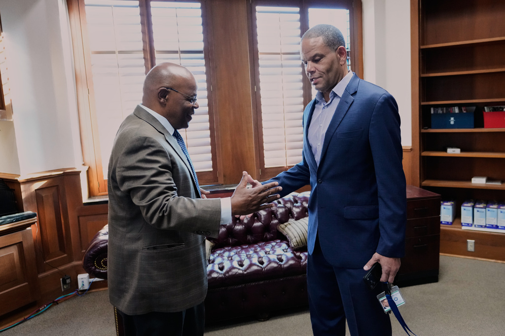 Calvin Duncan, left, an exoneree who was elected Orleans Parish clerk of criminal court, greets outgoing clerk Darren Lombard in his office on the first day of his term, Monday, May 4, 2026, in New Orleans. (AP Photo/Gerald Herbert)