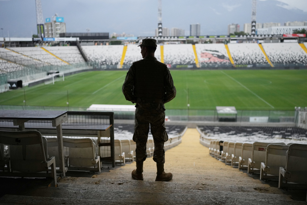 A soldier guards the Monumenta Stadium, where a polling station is set up beneath the stands, during the presidential runoff election in Santiago, Chile, Sunday, Dec. 14, 2025. (AP Photo/Natacha Pisarenko)