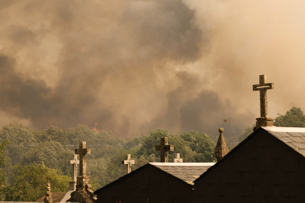 Plumes of smoke rise during a wildfire in Santa Baia De Montes, northwestern Spain, Thursday, Aug. 14, 2025. (AP Photo/Lalo R. Villar)