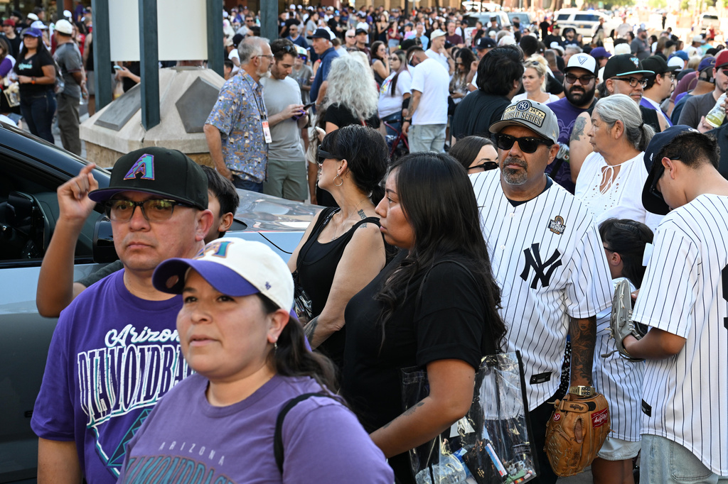Arizona Diamondbacks and New York Yankees fans wait for the ballpark gates to open prior to a baseball game, Saturday, Sept. 19, 2026, in Phoenix. (AP Photo/Caitlin O'Hara)