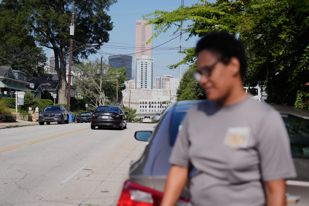 The city of Atlanta is seen behind Sechita McNair as she leaves her new apartment near Midtown on Aug. 1, 2025. (AP Photo/Brynn Anderson)
