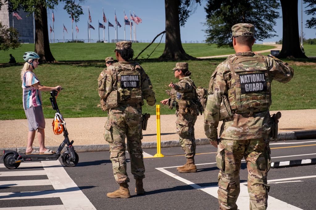 National Guard troops stop a young woman on a rental scooter near a closed intersection where President Donald Trump was holding an event, in Washington, Tuesday, Sept. 8, 2026. (AP Photo/J. Scott Applewhite)