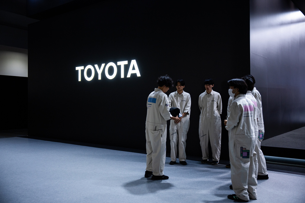Staff gather near a Toyota signage during the press day of the Japan Mobility Show, in Tokyo, Thursday, Oct. 30, 2025. (AP Photo/Louise Delmotte)