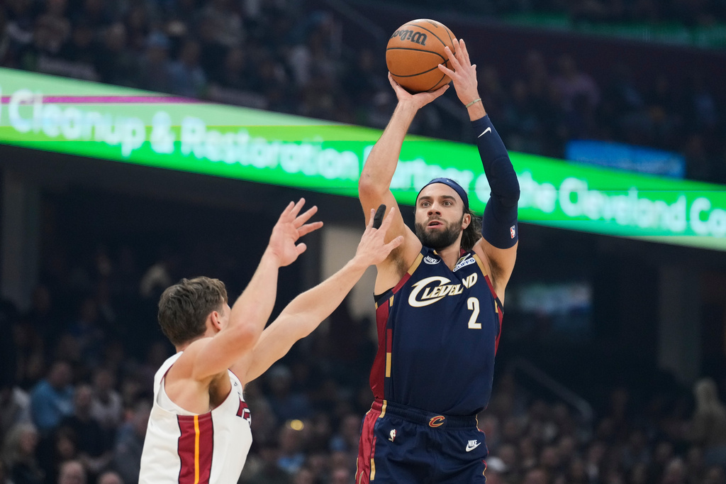 Cleveland Cavaliers guard Max Strus (2) shoots over Miami Heat guard Pelle Larsson, left, in the first half of an NBA basketball game in Cleveland, Friday, March 27, 2026. (AP Photo/Sue Ogrocki)