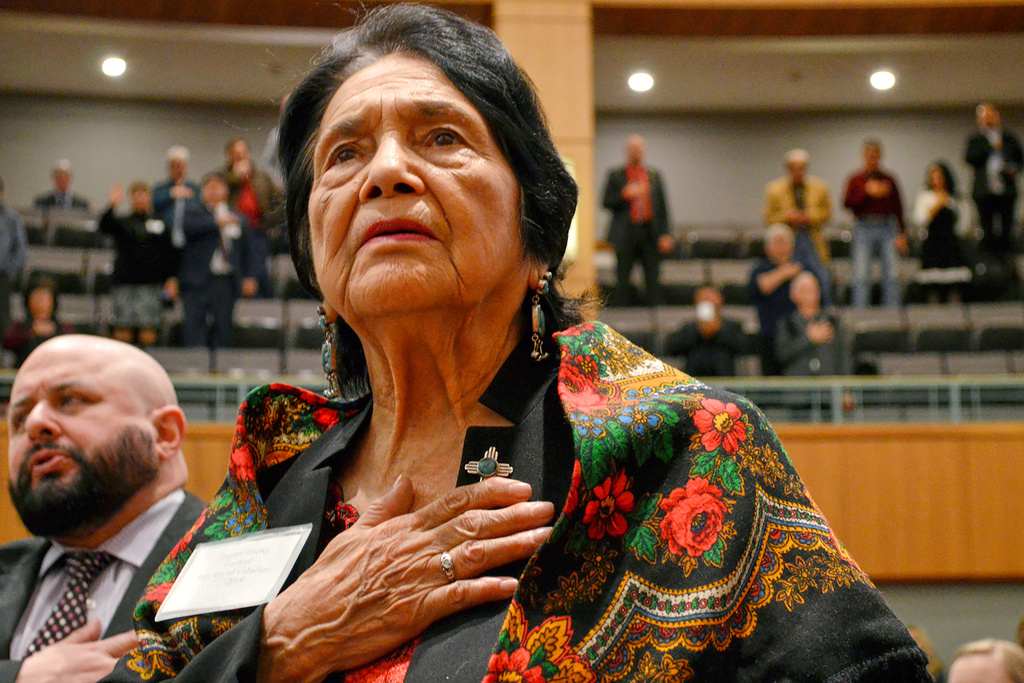 FILE - Dolores Huerta, the Mexican-American social activist who formed a farm workers union with Cesar Chavez, stands for the Pledge of Allegiance in Spanish while visiting the New Mexico Statehouse in Santa Fe. N.M., on Feb. 27, 2019. (AP Photo/Russell Contreras, File)