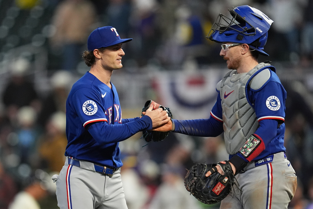 Texas Rangers relief pitcher Jacob Latz, left, and catcher Danny Jansen, right, shake hands after a baseball game against the Minnesota Twins, Saturday, Sept. 26, 2026, in Minneapolis. (AP Photo/Abbie Parr)