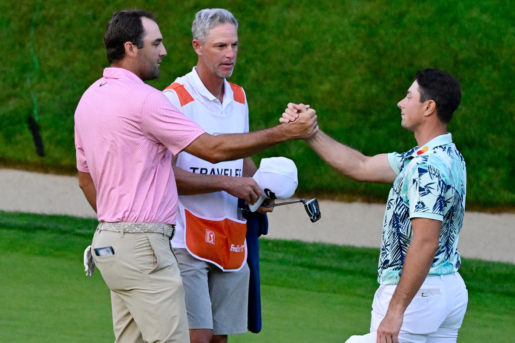 Scottie Scheffler, left, shakes hands with Viktor Hovland, right, of Norway, after finishing tied in the final round of the Travelers Championship golf tournament at TPC River Highlands, Sunday, June 28, 2026, in Cromwell, Conn. (AP Photo/Jessica Hill)