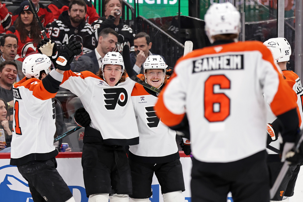 Philadelphia Flyers center Trevor Zegras (46) is congratulated by teammates after scoring his first goal of the game during the first period of an NHL hockey game against the New Jersey Devils, Tuesday, April 7, 2026, in Newark, N.J. (AP Photo/Adam Hunger)