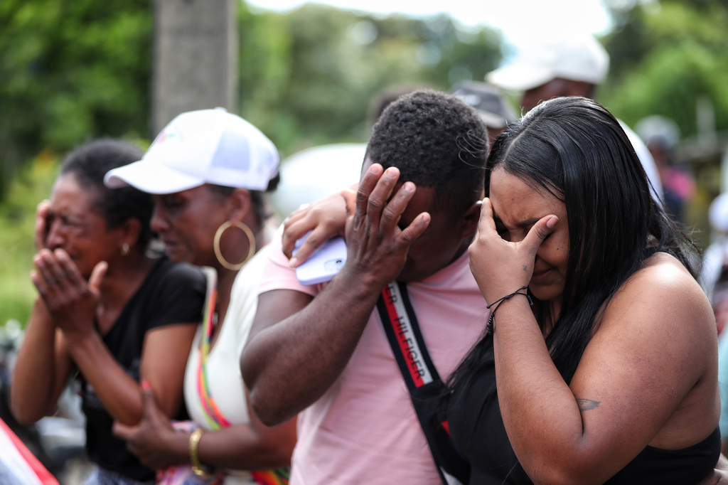 Relatives of a victim of an attack that killed at least 20 people on the Pan-American Highway, which authorities blamed on dissident former FARC rebels, cry during a funeral in Cajibio, Colombia, Monday, April 27, 2026. (AP Photo/Santiago Saldarriaga)