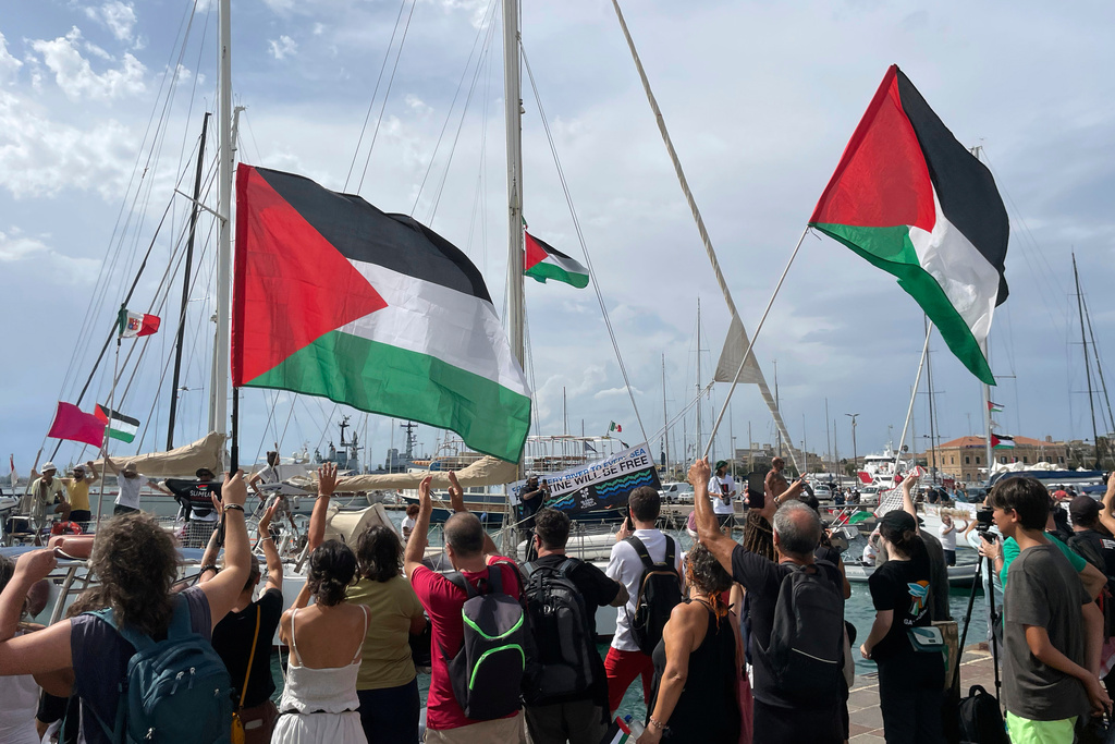 People carry Palestinian flags as they bid farewell to the Italian fleet of the Global Sumud Flotilla departing from the port of Siracusa, Italy, Thursday, Sept. 11, 2025. (Sebastiano Diamante/LaPresse via AP)