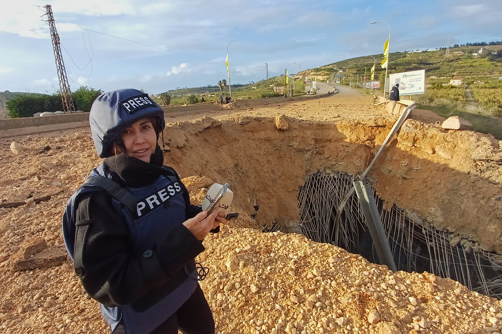 Lebanese journalist Amal Khalil, who works for the daily Al-Akhbar newspaper, reports near a destroyed bridge in Qasmiyeh, Lebanon, Sunday, March 22, 2026. (AP Photo/Mohammed Zaatari)
