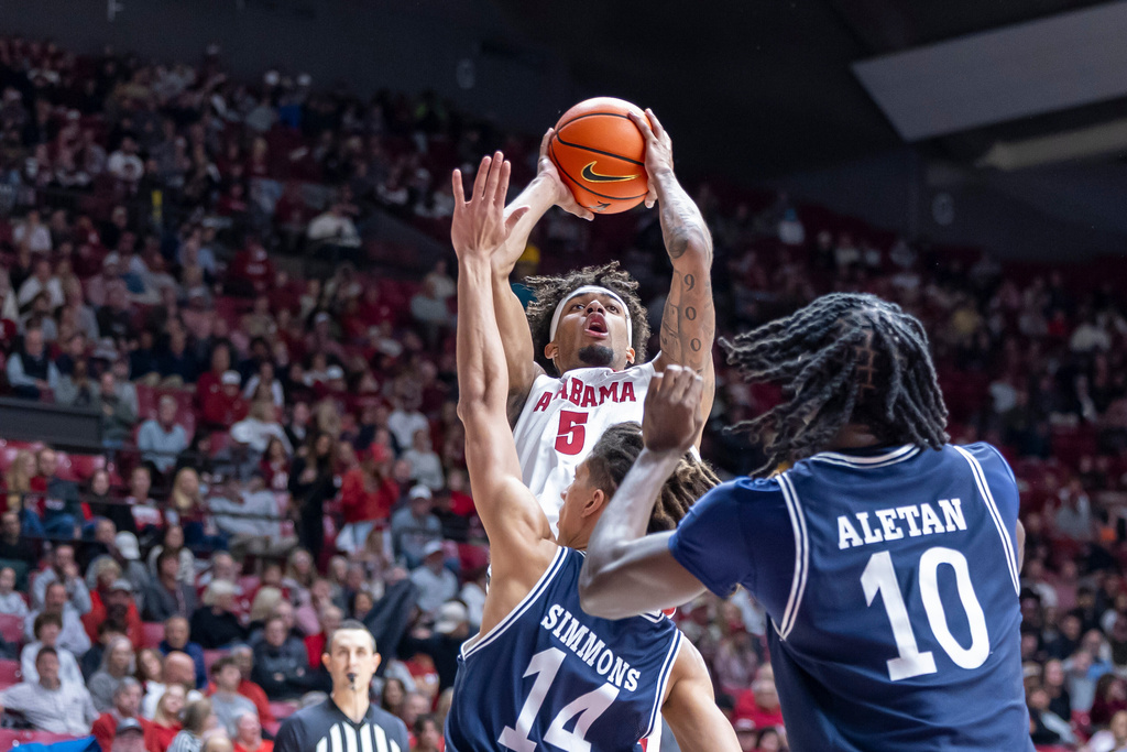 Alabama forward Amari Allen (5) shoots over Yale guard Casey Simmons (14) and center Samson Aletan (10) during the first half of an NCAA college basketball game Monday, Dec. 29, 2025, in Tuscaloosa, Ala. (AP Photo/Vasha Hunt)
