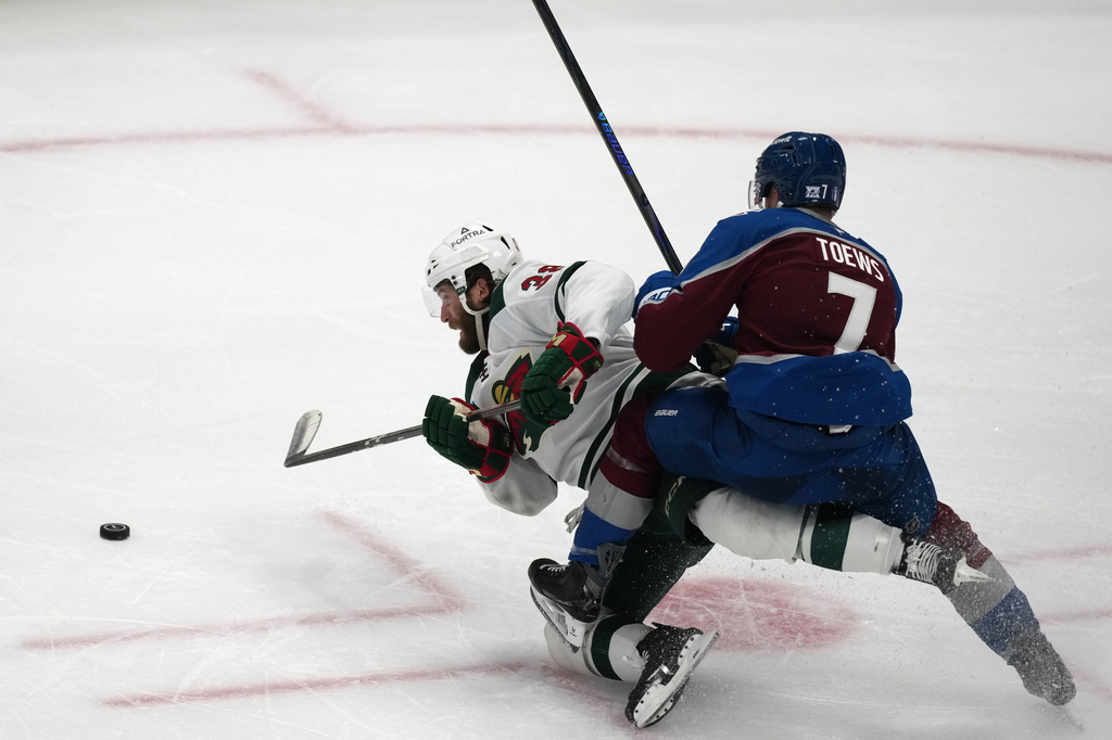 Minnesota Wild right wing Ryan Hartman, left, gets tangled up with Colorado Avalanche defenseman Devon Toews while pursuing the puck in the third period of Game 2 of an NHL hockey Stanley Cup second-round playoff series Tuesday, May 5, 2026, in Denver. (AP Photo/David Zalubowski)