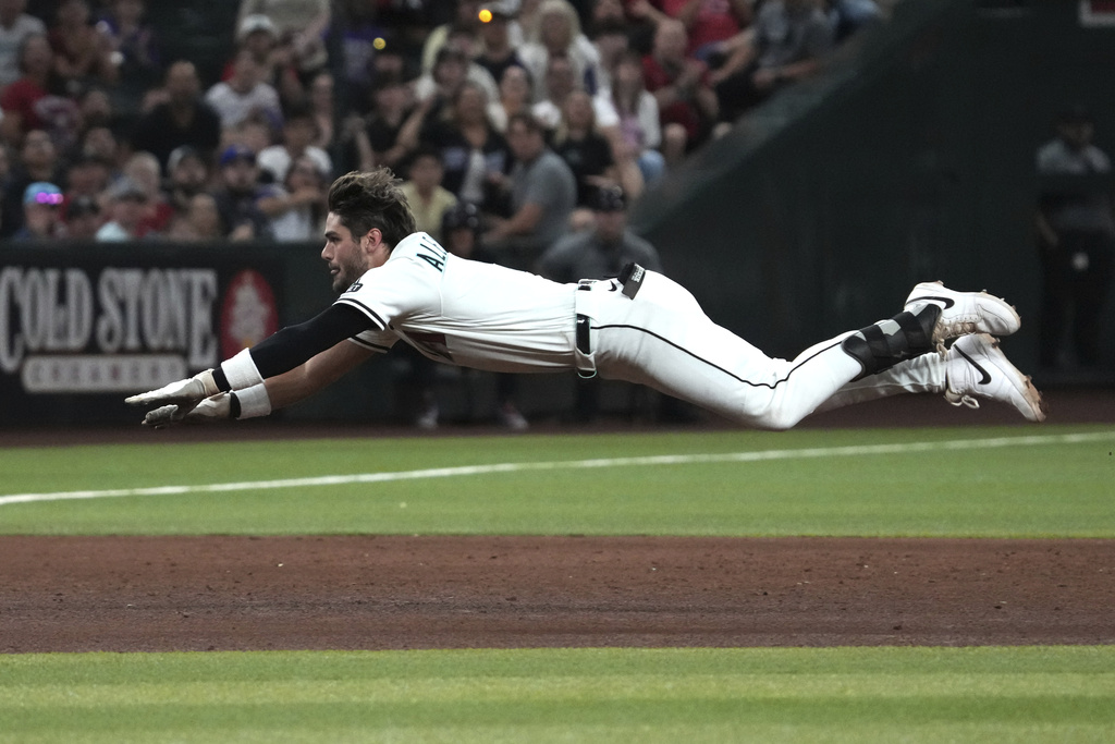 Arizona Diamondbacks' Blaze Alexander dives into third base after hitting an RBI triple against the Texas Rangers in the sixth inning of a baseball game, Monday, Sept. 1, 2025, in Phoenix. (AP Photo/Rick Scuteri)