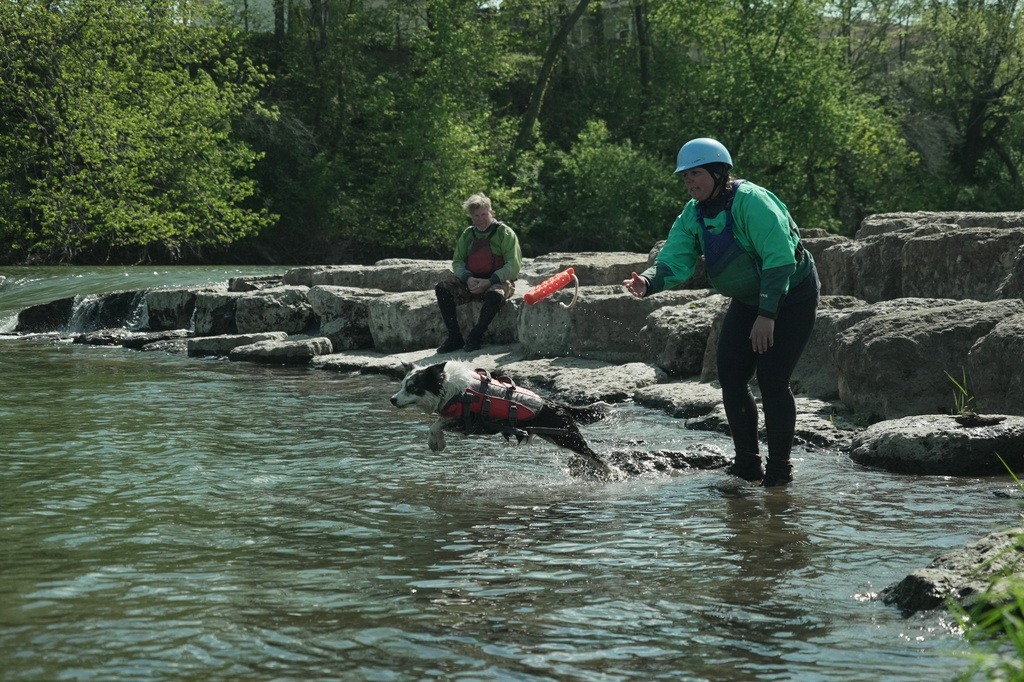 Hannah Ray J Childs, right, throws a toy for her dog as her husband Marty Colbert watches at a whitewater park she helped create on the Maquoketa River, Thursday, May 7, 2026, in Manchester, Iowa. (AP Photo/Brittany Peterson)