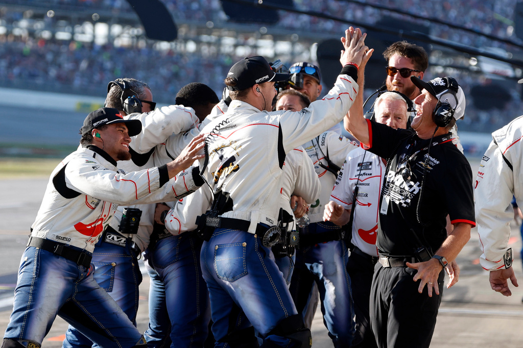 The crew of driver Carson Hocevar celebrate after his win in a NASCAR Cup Series auto race, Sunday, April 26, 2026, in Talladega, Ala. (AP Photo/Butch Dill)