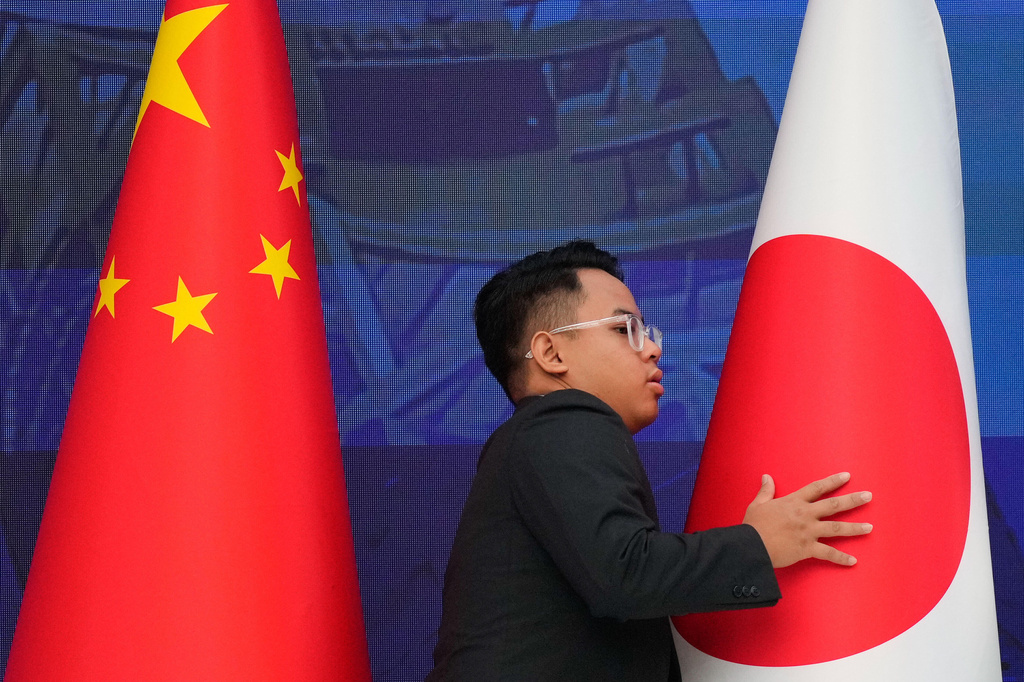 FILE - A staff organise flags from China, left, and Japan before the start of the 28th ASEAN Plus Three Summit in Kuala Lumpur, Malaysia, on Oct. 27, 2025. (AP Photo/Vincent Thian, Pool, File)