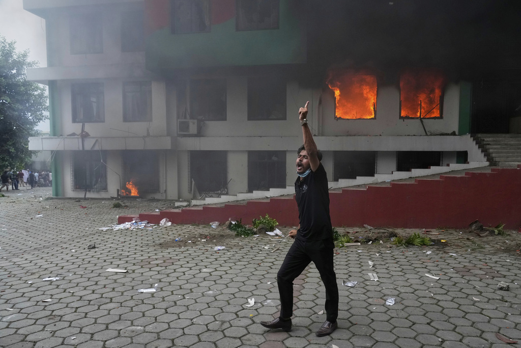 A protester shouts slogans after burning Nepalese congress party central office during protests against social media ban and corruption in Kathmandu, Nepal, Tuesday, Sept. 9, 2025. (AP Photo/Niranjan Shrestha)