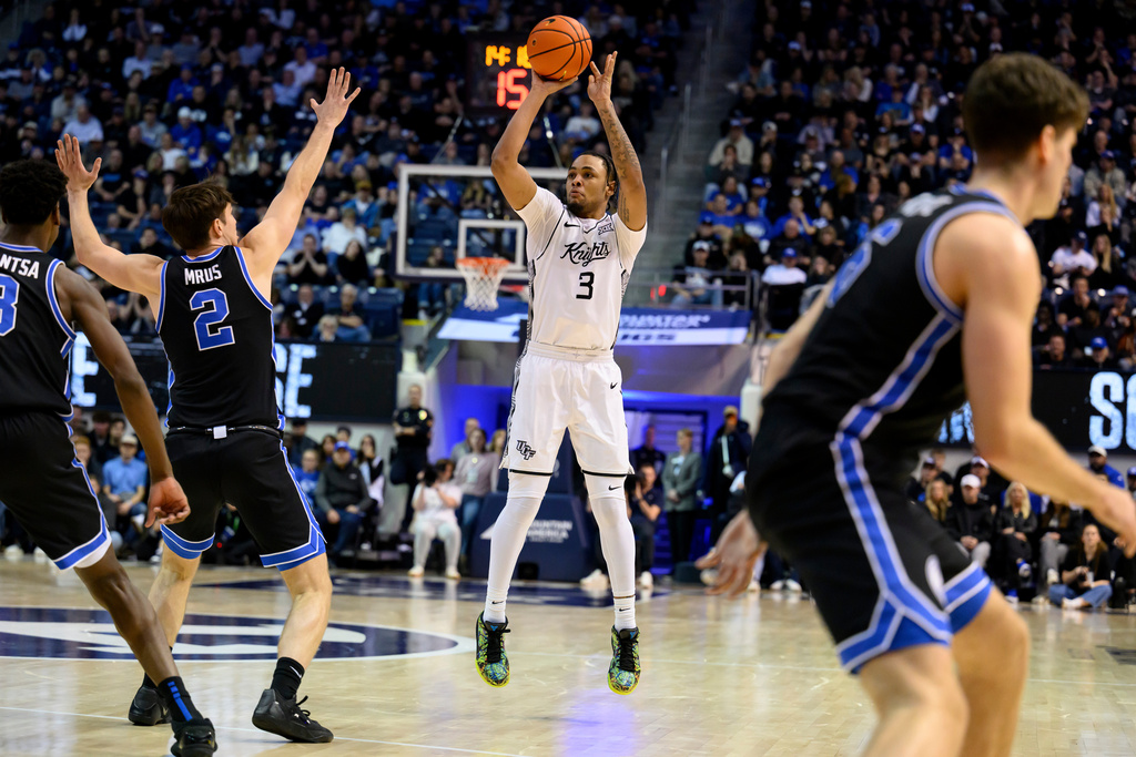 UCF guard George Beale Jr. (3) shots over BYU forward Tyler Mrus (2) during the second half an NCAA college basketball game, Tuesday, Feb. 24, 2026, in Provo, Utah. (AP Photo/Tyler Tate)