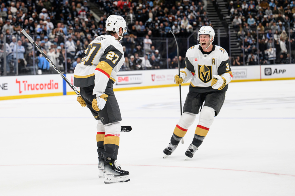 Vegas Golden Knights Brayden McNabb, right, celebrates with Shea Theodore, left, who scored the winning goal during the overtime period of Game 4 of a first-round NHL hockey Stanley Cup playoff series against the Utah Mammoth, Monday, April 27, 2026, in Salt Lake City. (AP Photo/Tyler Tate)