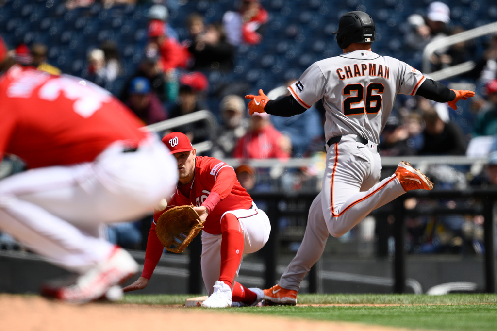 San Francisco Giants' Matt Chapman (26) is safe at first with a single against Washington Nationals first baseman Curtis Mead, center, during the third inning of a baseball game, Sunday, April 19, 2026, in Washington. (AP Photo/Nick Wass)