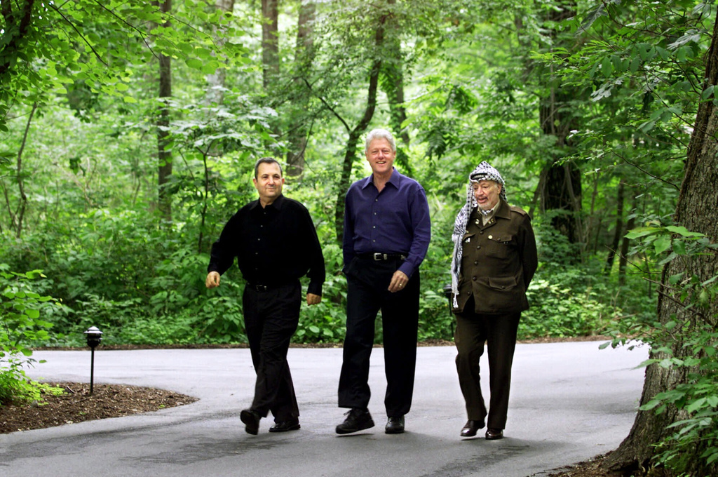 FILE - President Bill Clinton, Israeli Prime Minister Ehud Barak, left, and Palestinian leader Yasser Arafat, right, walk on the grounds of Camp David, Md., Tuesday July 11, 2000, at the start of the Mideast summit. (AP Photo/Ron Edmonds, File)