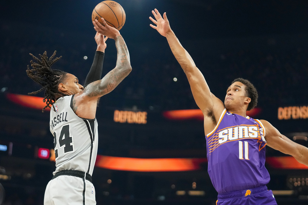 San Antonio Spurs guard Devin Vassell (24) looks to shoot against San Antonio Spurs forward Carter Bryant (11) during the first half of an NBA basketball game in Phoenix, Sunday, Nov. 23, 2025. (AP Photo/Darryl Webb)