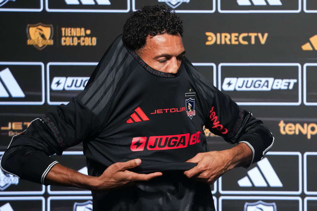 Cape Verde goalkeeper Vozinha puts on his new Colo Colo jersey during his presentation as a new player at Monumental stadium in Santiago, Chile, Tuesday, Aug. 4, 2026. (AP Photo/Esteban Felix)