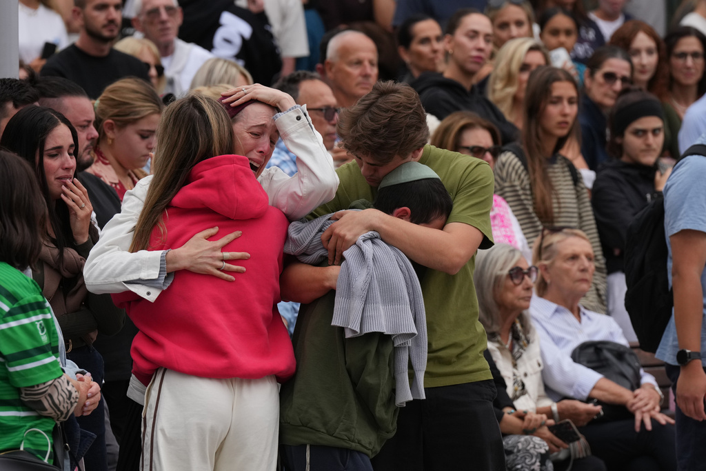 Family members of a victim from Sunday's shooting mourn at a flower memorial made after the shooting at the Bondi Pavilion at Bondi Beach on Tuesday, Dec. 16, 2025, in Sydney, Australia. (AP Photo/Mark Baker)