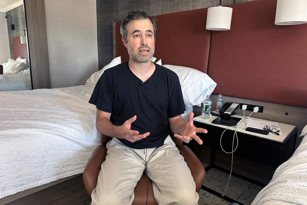 Mark Bray, a Rutgers assistant professor of history, waits in a hotel room in Newark, N.J., before a planned flight to Spain on Thursday, Oct. 9, 2025. (AP Photo/Ted Shaffrey)