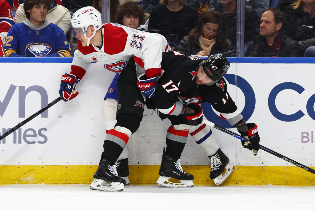 Montréal Canadiens defenseman Kaiden Guhle (21) is checked by Buffalo Sabres left wing Jason Zucker (17) during the first period of an NHL hockey game, Thursday, Jan. 15, 2026, in Buffalo, N.Y. (AP Photo/Jeffrey T. Barnes)