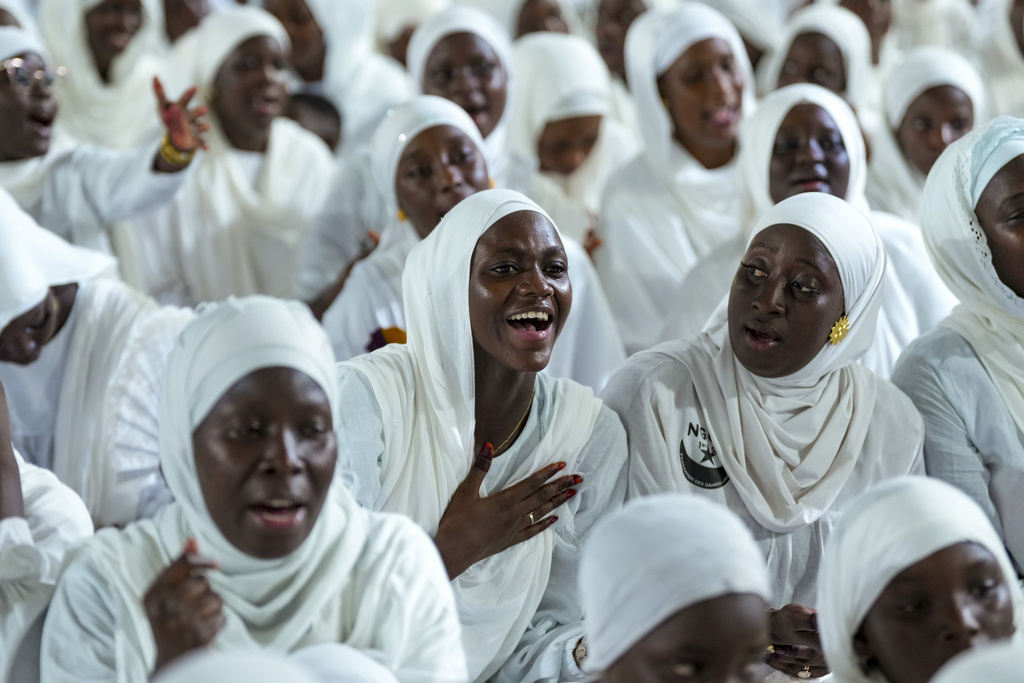 A woman recites prayers as people mark Prophet Muhammad's birthday, known as Mawlid, in Dakar, Senegal, Friday, Sept. 5, 2025. (AP Photo/Misper Apawu)