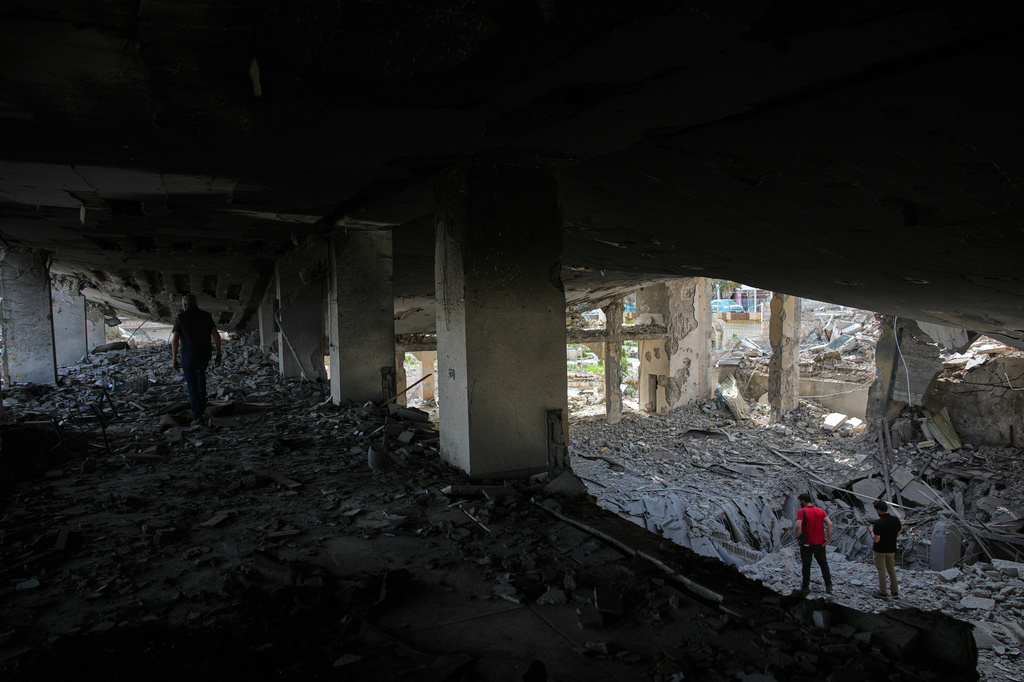 People walk among debris inside a mosque destroyed in an Israeli airstrike in Jibchit, southern Lebanon, Friday, April 17, 2026, following a ceasefire between Israel and Hezbollah. (AP Photo/Hassan Ammar)