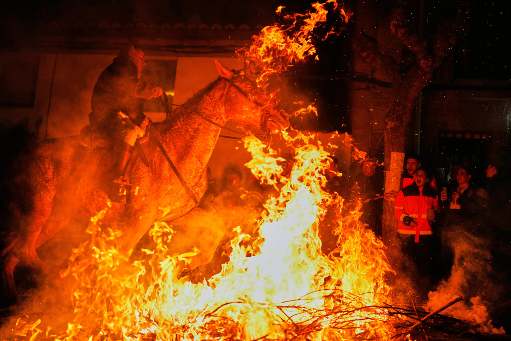 A man rides a horse through a bonfire as part of a ritual in honor of Saint Anthony the Abbot, the patron saint of domestic animals, in San Bartolome de Pinares, Spain, Friday, Jan. 16, 2026. (AP Photo/Manu Fernandez)