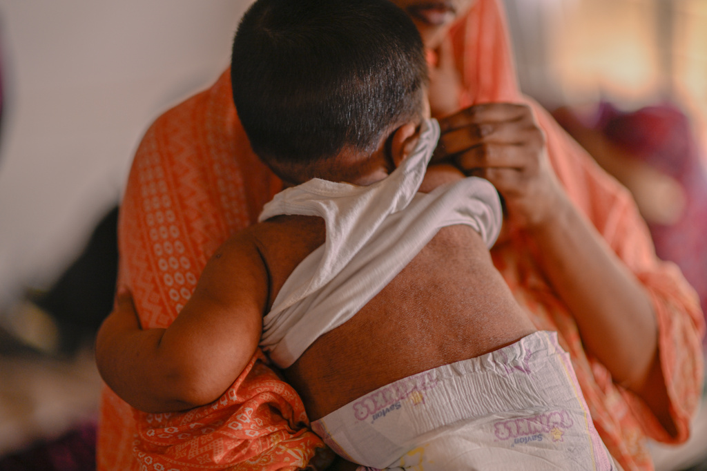 A woman comforts her child receiving treatment for measles at the Infectious Diseases Hospital in Dhaka, Bangladesh, Monday, April 6, 2026, amid a countrywide outbreak. (AP Photo/Mahmud Hossain Opu)