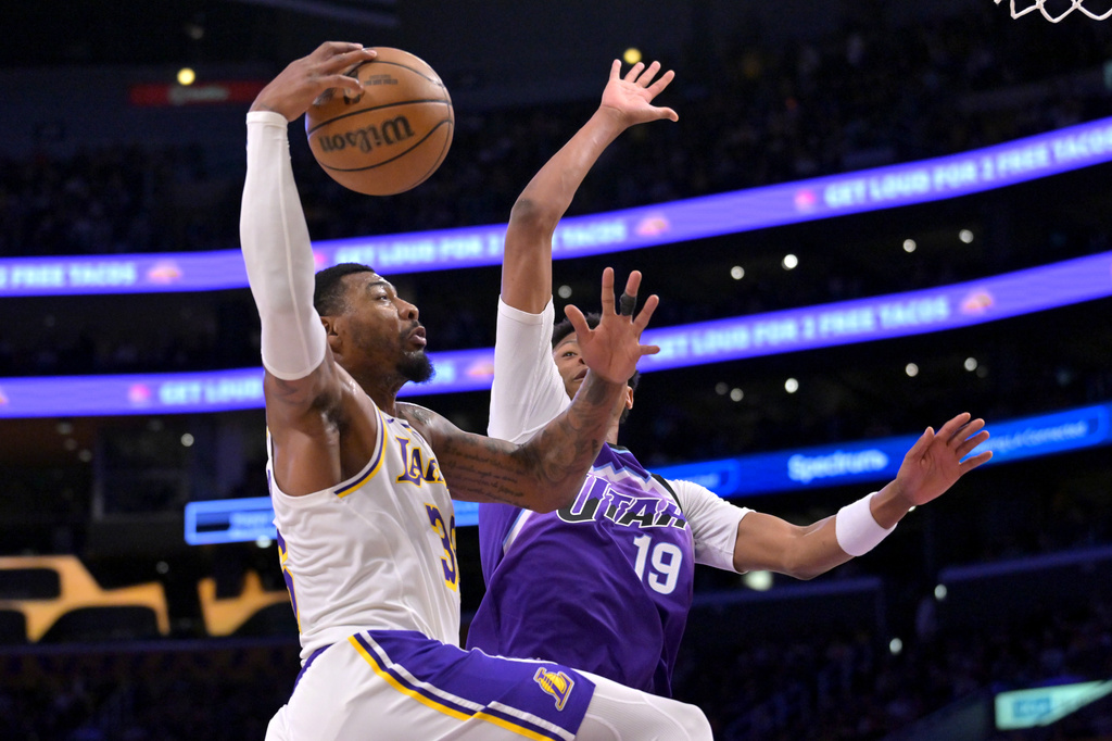 Los Angeles Lakers guard Marcus Smart is defended by Utah Jazz guard Ace Bailey (19) as he drives to the basket during the first half of an NBA basketball game Sunday, April 12, 2026, in Los Angeles. (AP Photo/Jayne Kamin-Oncea)