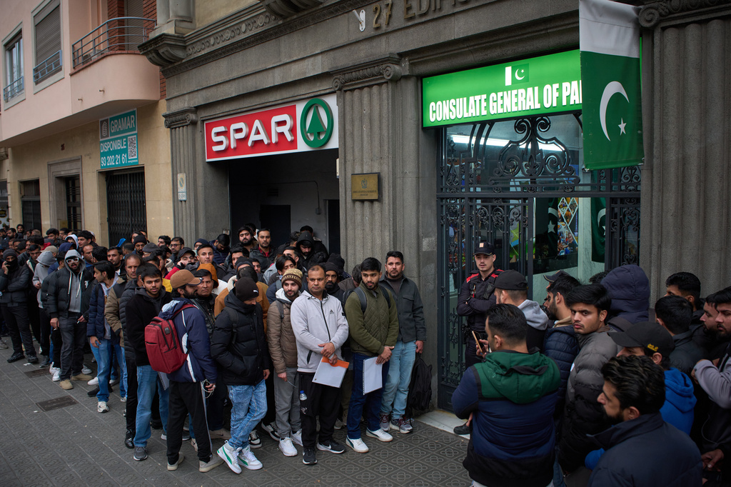 FILE - A crowd of Pakistanis gather at the entrance of the Pakistani consulate in Barcelona, Spain, Thursday, Jan. 29, 2026, following the Spanish government's decision to grant residency and work permits to potentially hundreds of thousands of immigrants. (AP Photo/Emilio Morenatti, File)
