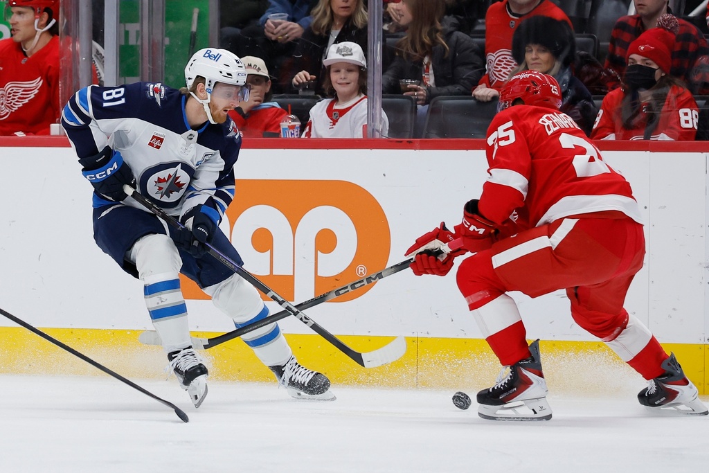 Winnipeg Jets left wing Kyle Connor (81) brings the puck up the ice against Detroit Red Wings defenseman Jacob Bernard-Docker, right, during the first period of an NHL hockey game, Wednesday, Dec. 31, 2025, in Detroit. (AP Photo/Duane Burleson)
