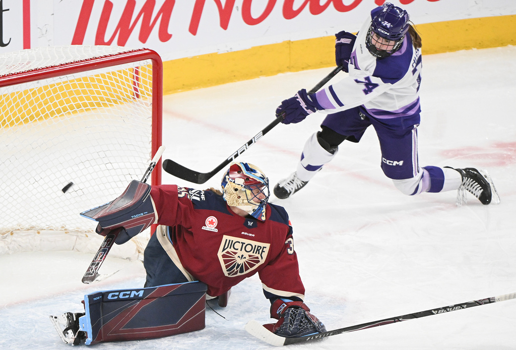 Minnesota Frost's Abby Hustler (74) shoots against Montreal Victoire goaltender Ann-Renee Desbiens, left, during second-period PWHL hockey game action in Laval, Quebec, Sunday, March 1, 2026. (Graham Hughes/The Canadian Press via AP)