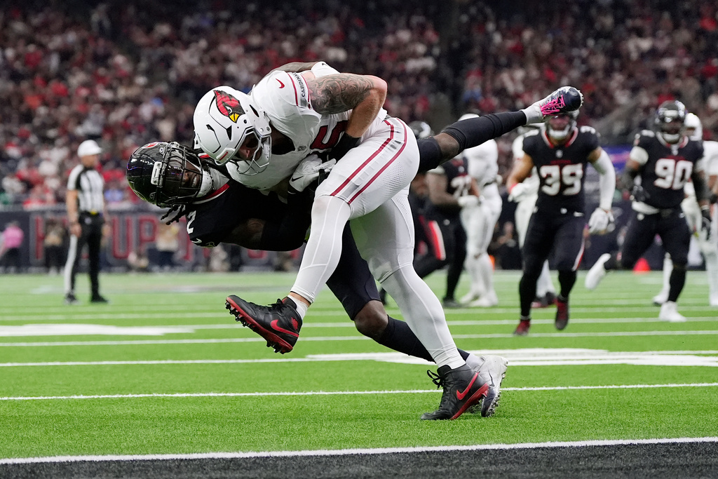 Arizona Cardinals tight end Trey McBride, right, is tackled by Houston Texans safety Calen Bullock (2) during the first half of an NFL football game Sunday, Dec. 14, 2025, in Houston. (AP Photo/Ashley Landis)
